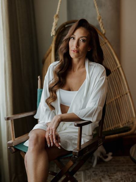 Candid of bride laughing while seated in robe during getting ready at The Ben Autograph Collection Hotel Palm Beach