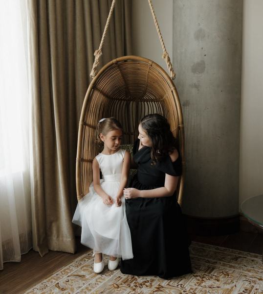 Maid of honor chatting with bride seated in robe at The Ben Autograph Collection Hotel Palm Beach