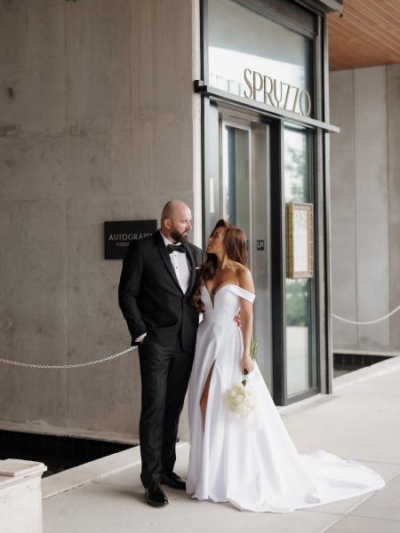 Bride and groom holding hands in front of hotel exterior at The Ben Autograph Collection Hotel Palm Beach