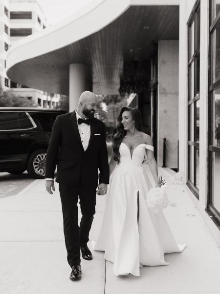 Close-up of bride and groom holding hands while walking outside at The Ben Autograph Collection Hotel Palm Beach