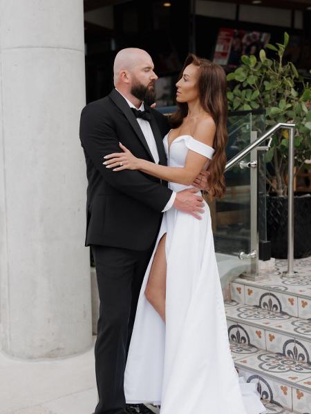 Close-up of bride and groom holding hands while walking outside at The Ben Autograph Collection Hotel Palm Beach