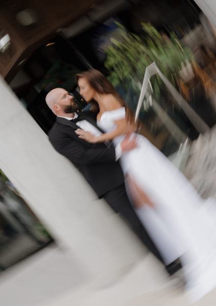 Wide-angle shot of couple walking with hotel architecture in the background at The Ben Autograph Collection Hotel Palm Beach
