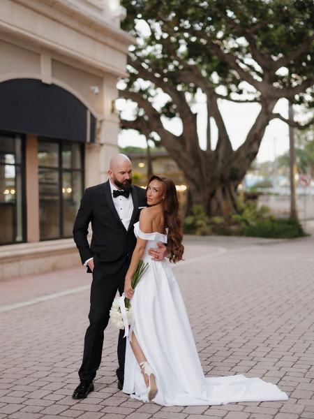 Bride and groom holding hands in hotel courtyard at The Ben Autograph Collection Hotel Palm Beach
