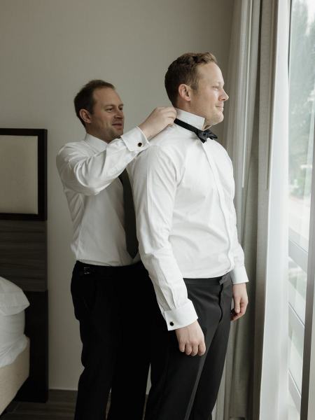 Groom looking in mirror while fixing hair and tie at Spanish Monastery Miami