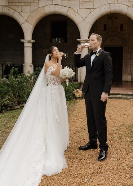 Newlyweds holding hands while walking down aisle at Spanish Monastery Miami