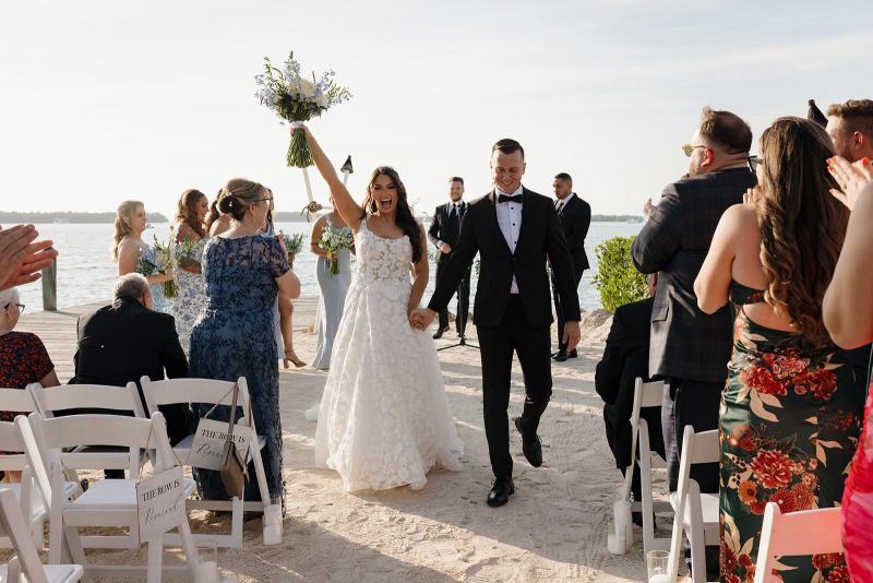 Newlyweds walking down aisle together after first kiss at Islamorada Fish Company Florida Keys