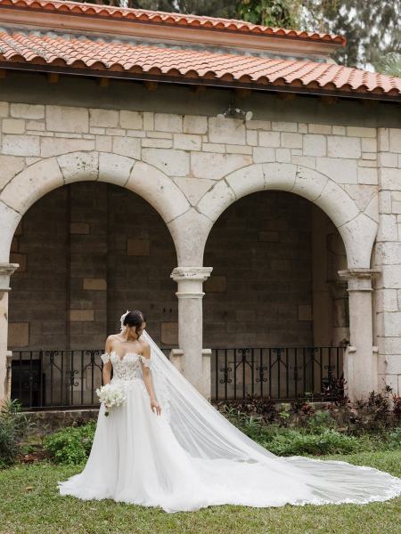 Bride adjusting veil in bridal portrait at Spanish Monastery Miami