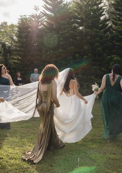 Bride putting on wedding dress with bridesmaids at Cinco Farms Miami