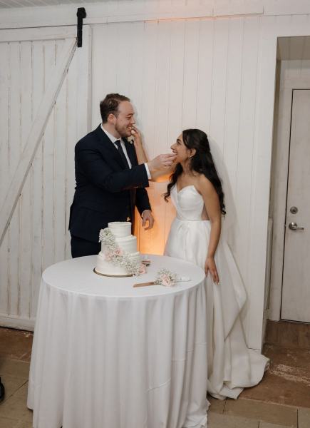 Bride feeding groom a piece of wedding cake at Cinco Farms Miami