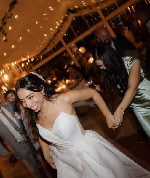 Guests raising hands and cheering while dancing at Cinco Farms Miami