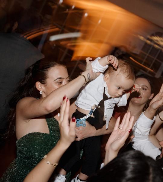 Guests raising hands and cheering while dancing at Cinco Farms Miami