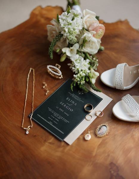 Flat lay of bride’s wedding rings on invitation at Cinco Farms Miami