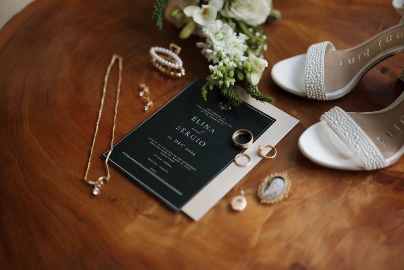Flat lay of wedding invitation suite with bouquet at Cinco Farms Miami