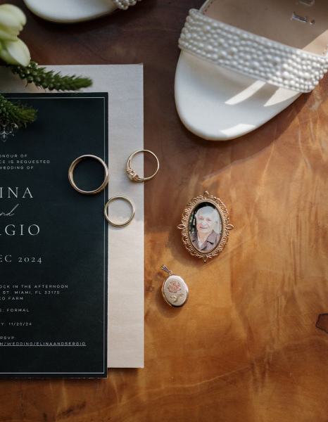 Flat lay of invitation and floral details on wood table at Cinco Farms Miami