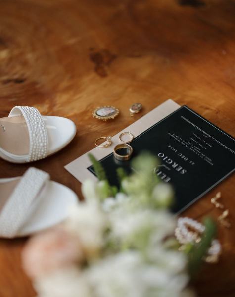 Flat lay of invitation and floral details on wood table at Cinco Farms Miami
