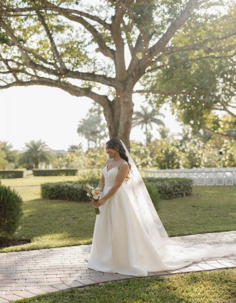 Bride leaning against wall for portrait at Cinco Farms Miami