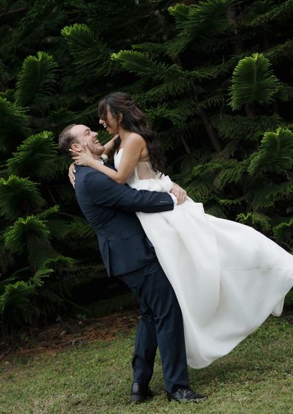 Bride laughing as groom picks her up at Cinco Farms Miami