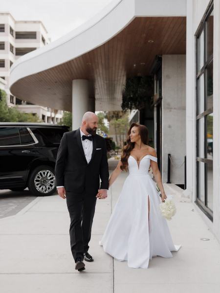 Bride and groom walking hand-in-hand on hotel grounds at The Ben Autograph Collection Hotel Palm Beach